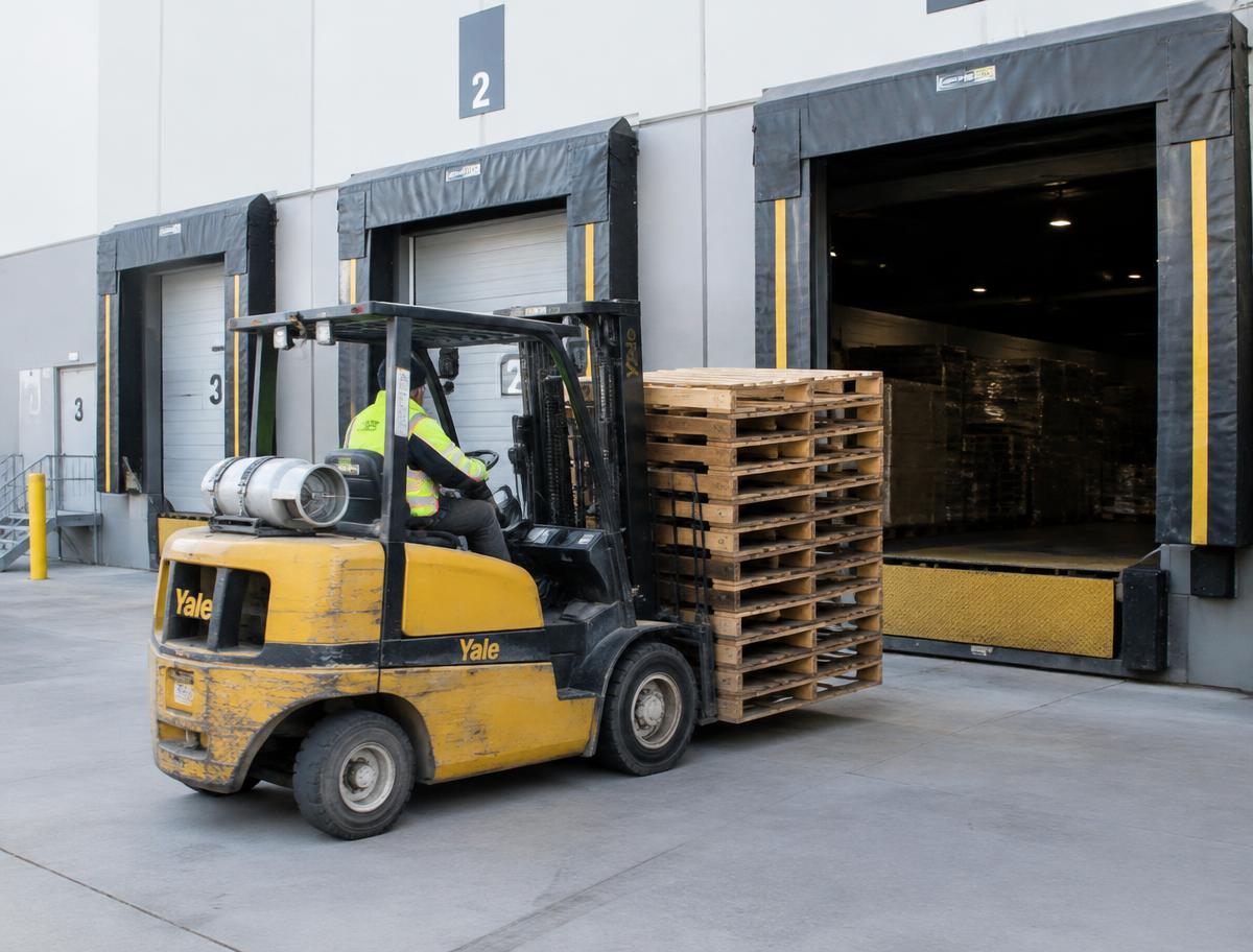Forklift moving pallets at a loading dock